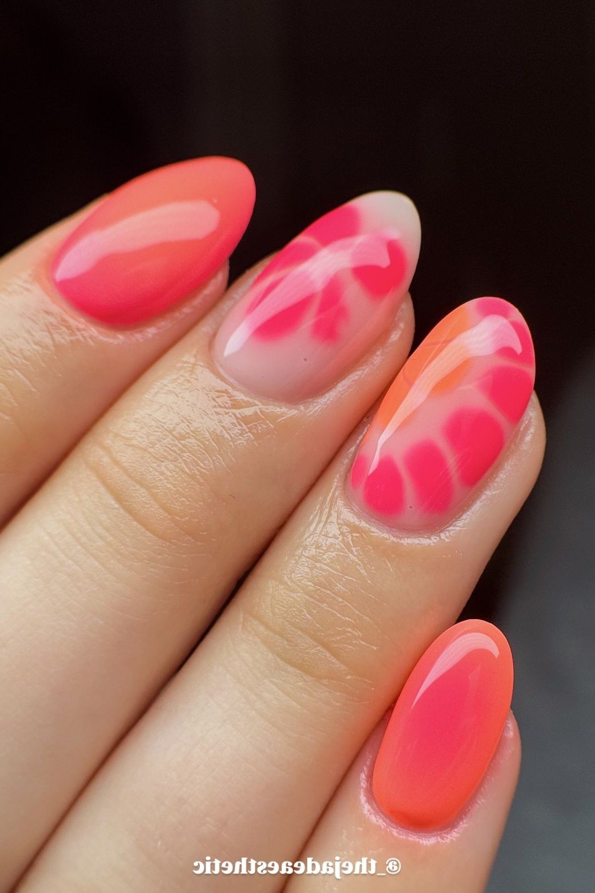 Coral and pink watercolor marble nails on nude almond base, dreamy summer nail art
