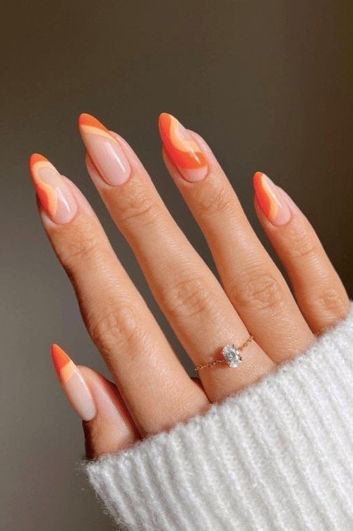 Nude almond nails with wavy orange French tips, modern summer French tip nails