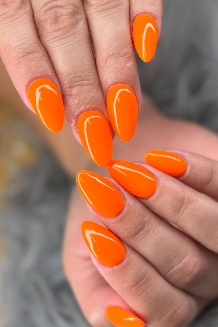 Neon orange oval nails with high gloss finish, vibrant summer orange nails