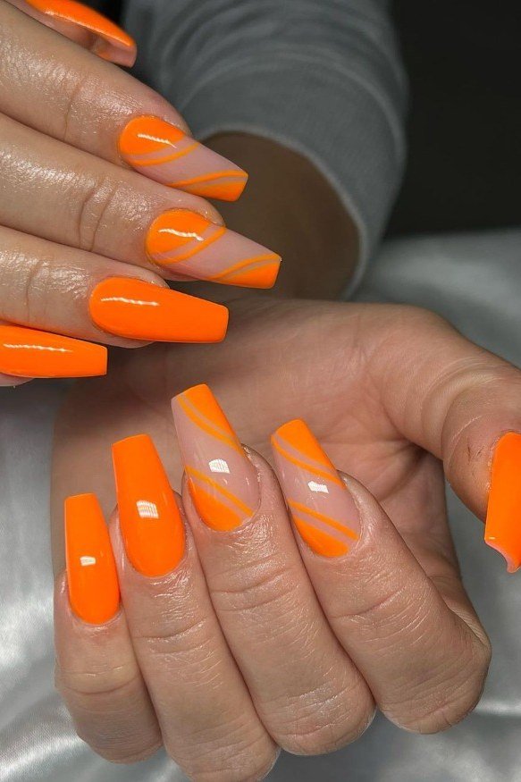 Neon orange coffin nails with orange swirl line art on nude accents, trendy summer nails