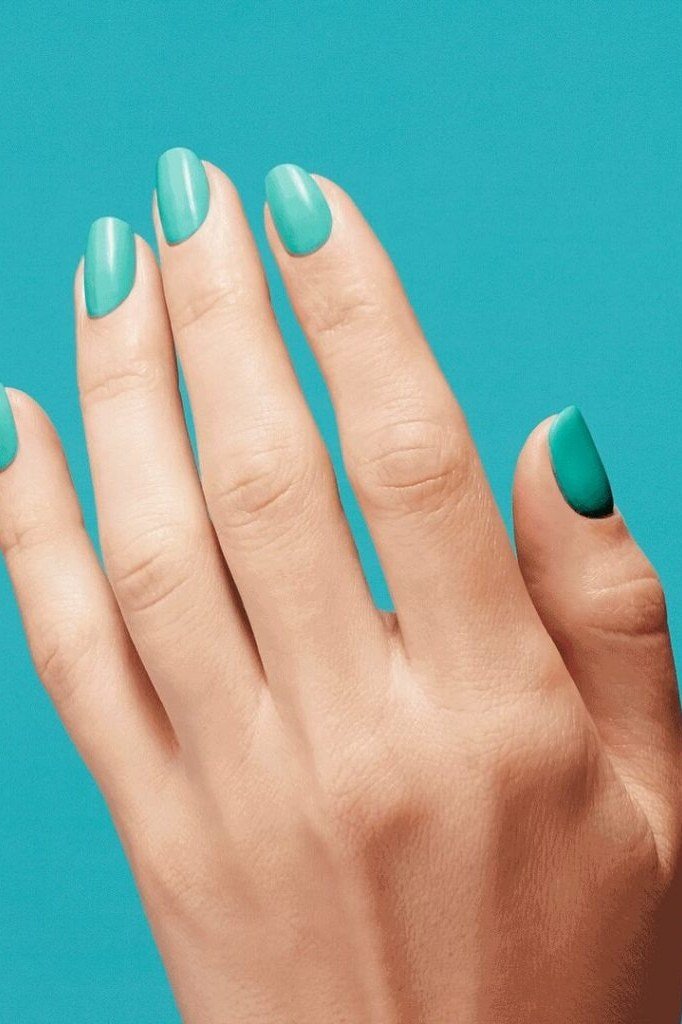 Solid turquoise short almond nails against teal background, simple bold summer nails
