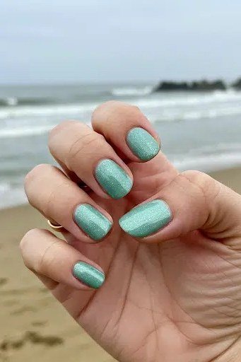 Mint green metallic shimmer short nails at the beach, sparkling summer mint nails