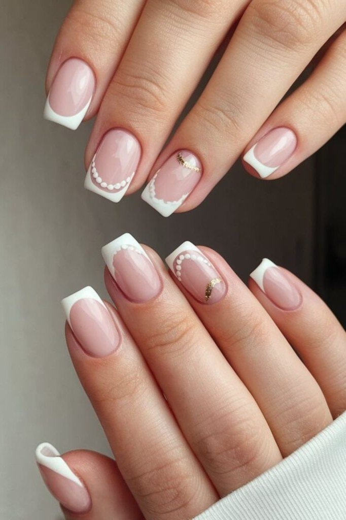Nude nails with white French tips, pearl dot accents and gold flecks, bridal summer nails