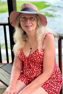 Older woman wearing red floral v-neck sundress on porch - summer sundresses for women over 60