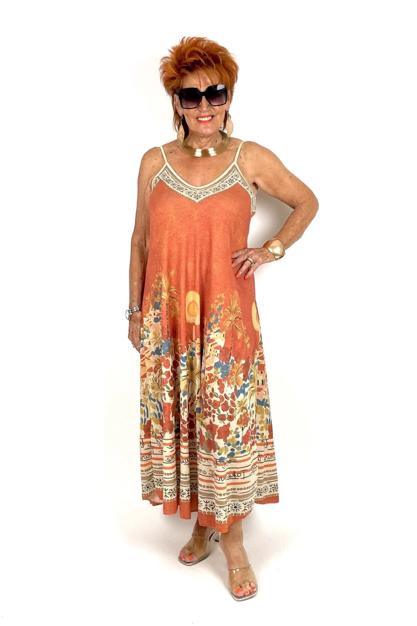 Older woman wearing orange floral maxi sundress, white studio - summer sundresses for women over 60