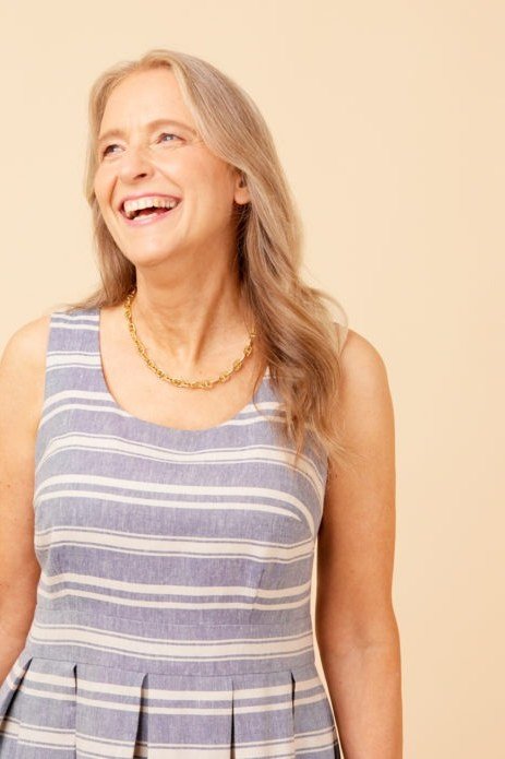 Older woman wearing gray striped sleeveless midi dress, studio - summer sundresses for women over 60
