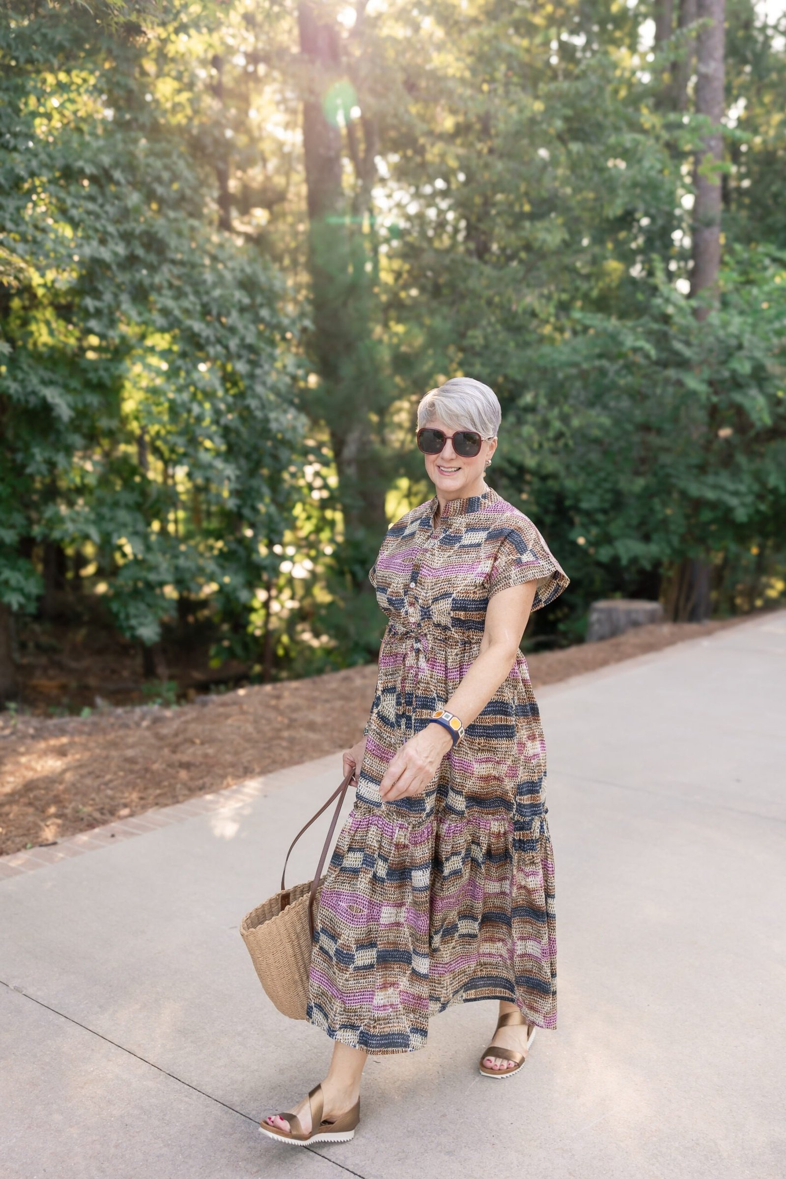 Older woman wearing colorful print maxi sundress on path - summer sundresses for women over 60