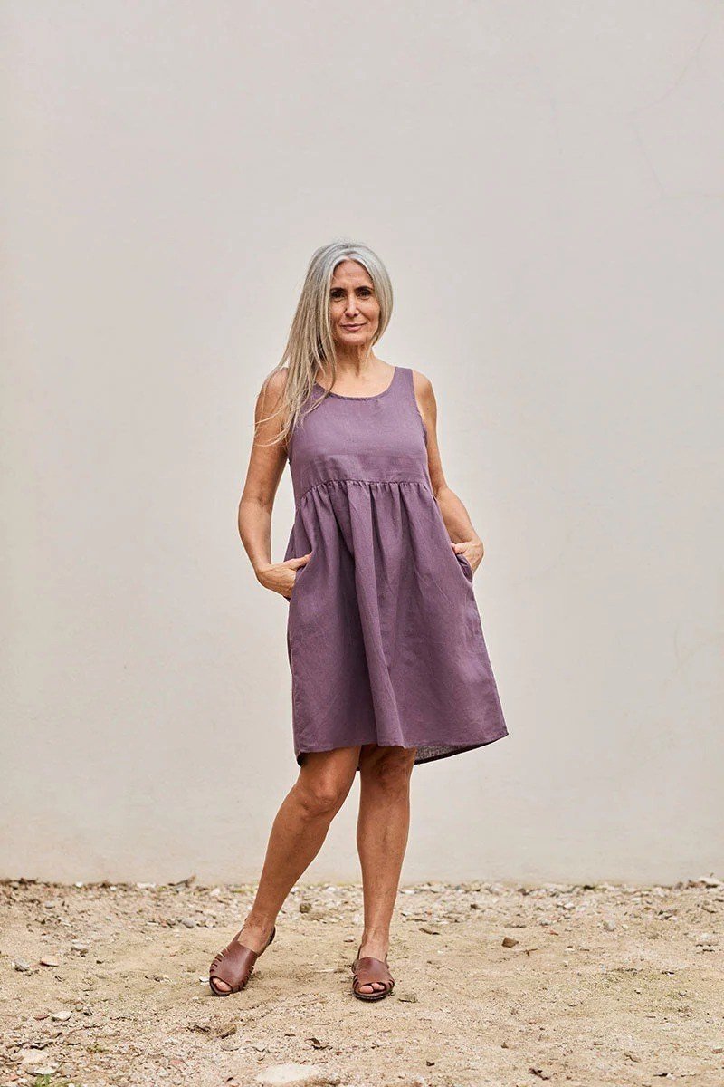 Older woman wearing purple sleeveless mini dress, studio - summer sundresses for women over 60
