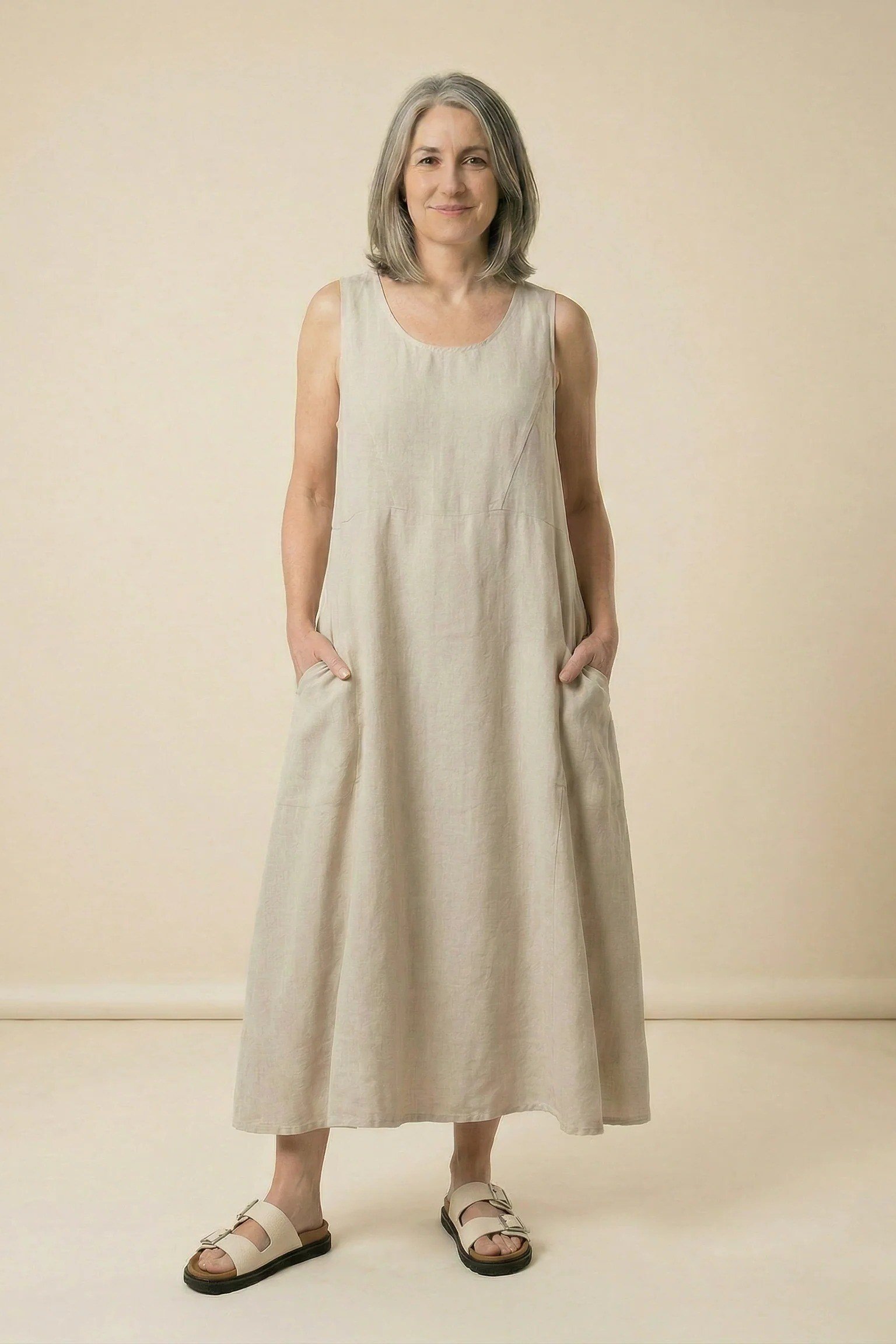 Older woman wearing gray hair, beige linen maxi dress, studio - summer sundresses for women over 60