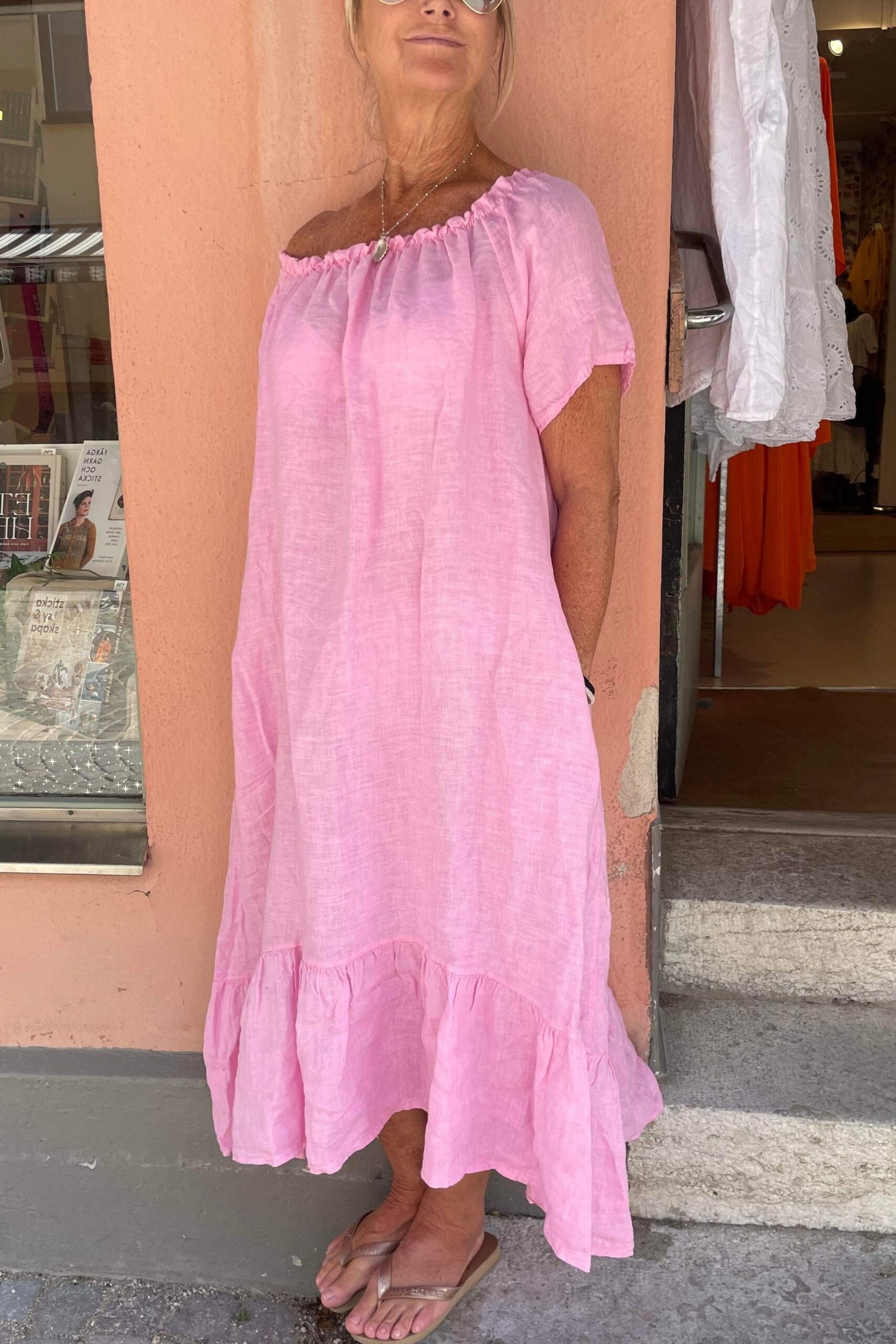 Older woman wearing pink linen midi sundress on street - summer sundresses for women over 60