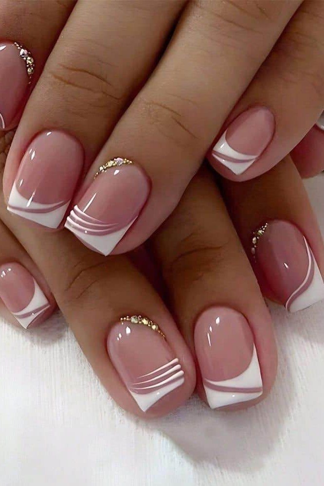 French tip nails with white line detail and gold bead accents