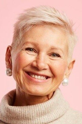 Blonde pixie haircut for women over 60 on pink background