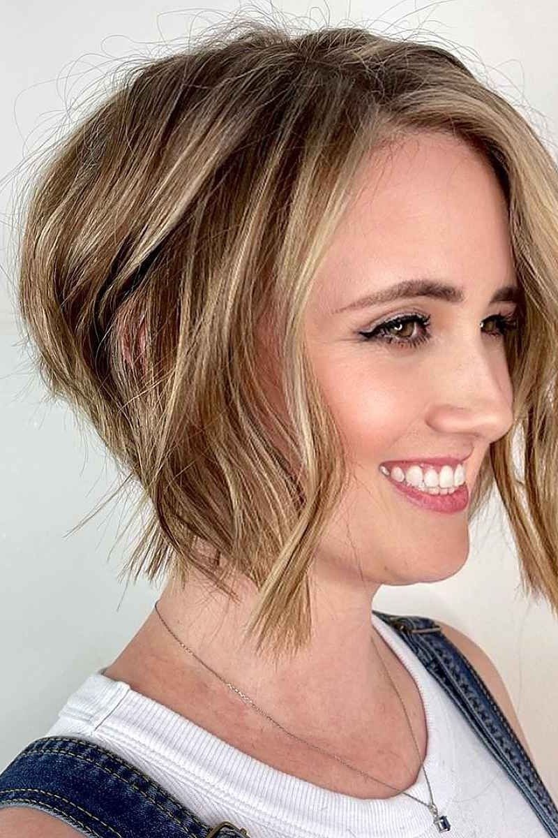 Layered bob haircut for thin fine hair over 50, side view, blonde layered bob with volume at the crown on a smiling mature woman.