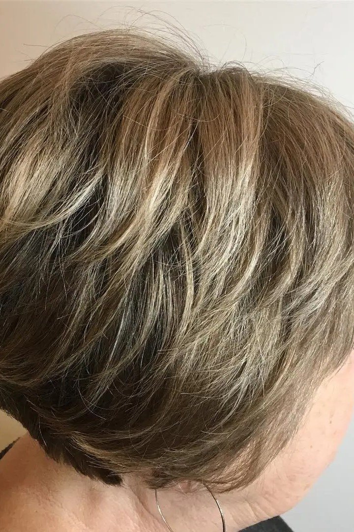 Layered bob haircut for thin fine hair over 50, back three-quarter view, ash-blonde stacked bob