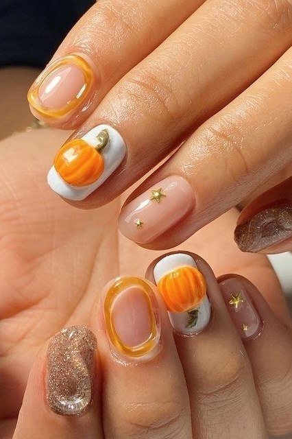 Pumpkin nail art with gold outlines on short nude nails