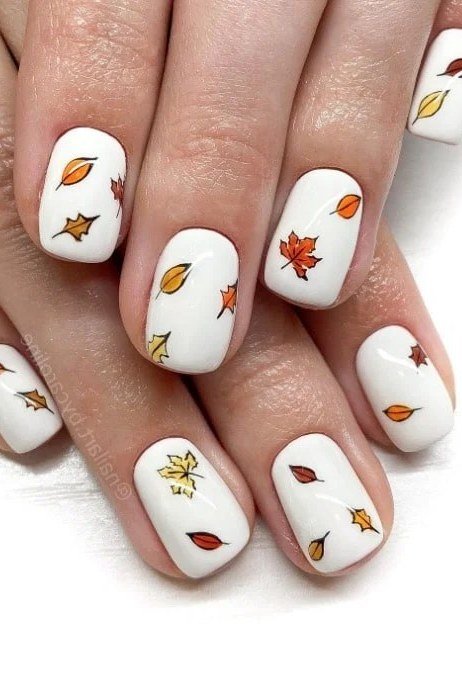 Tiny leaf sprinkles on white nails