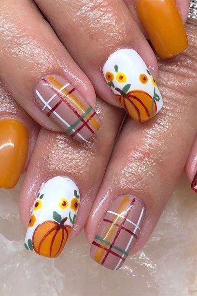 White nails with pumpkin and plaid nail art and orange solids