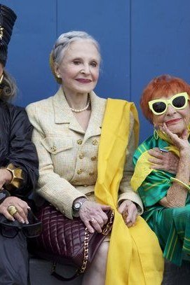Three women in bold color blocked outfits on bench - trendy outfits for women over 70
