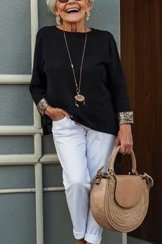 Older woman black blouse with white skinny jeans - trendy outfit idea for women over 70