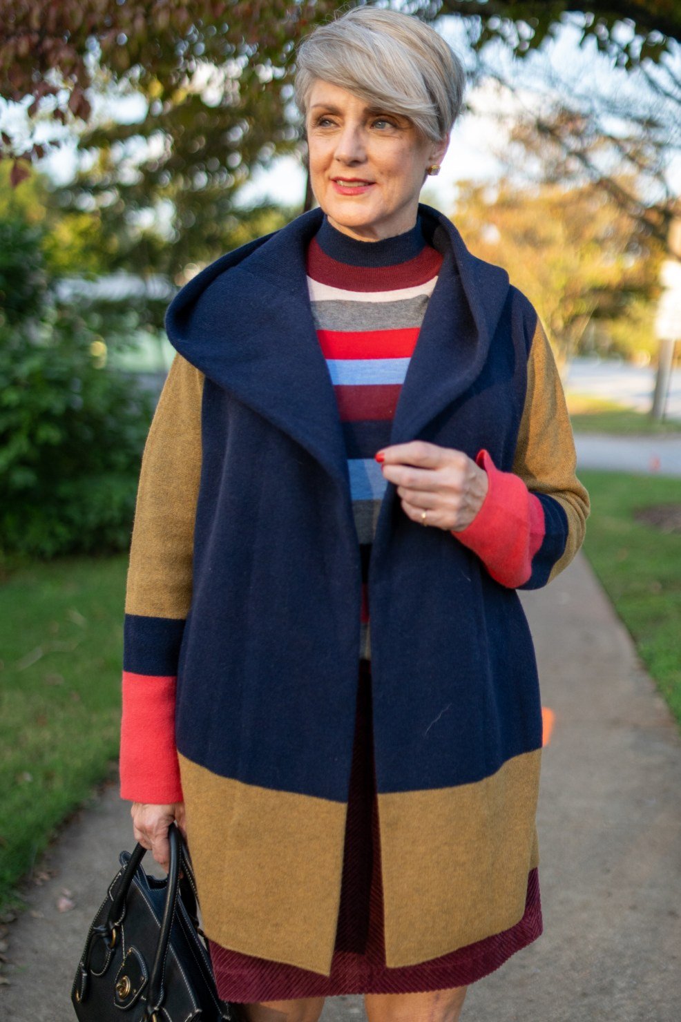 Fall turtleneck outfit for women over 50: striped turtleneck with colorblock coat, outdoors