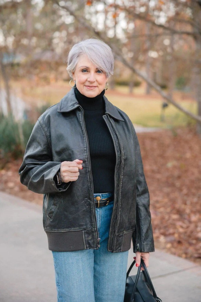 Fall turtleneck outfit for women over 50: black turtleneck with gray zip jacket, blue jeans