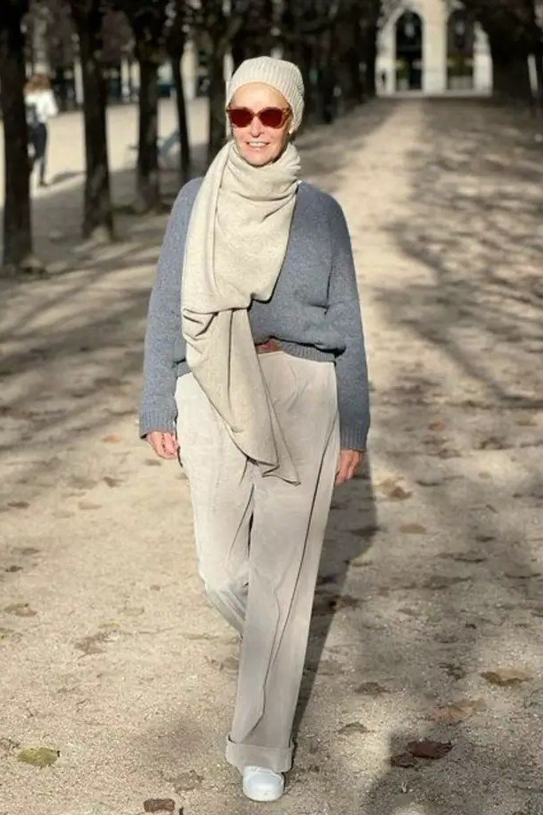 Fall turtleneck outfit for women over 50: gray turtleneck with oversized patterned scarf, walking