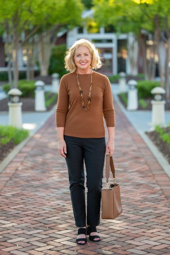 Fall turtleneck outfit for women over 50: brown turtleneck with dark trousers, brick walkway