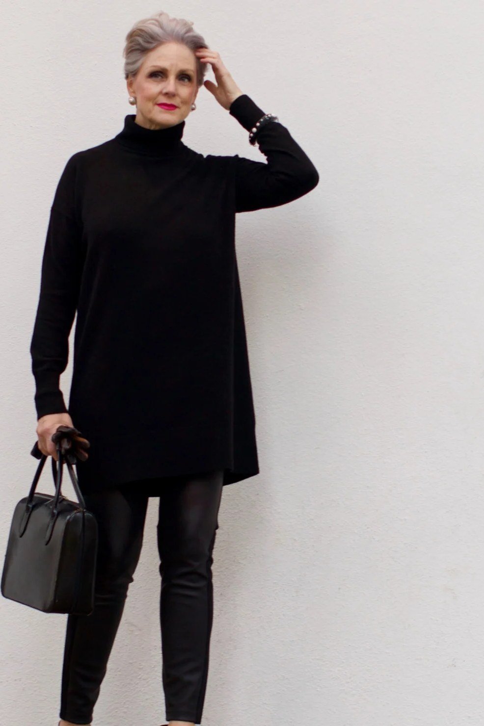 Fall turtleneck outfit for women over 50: black tunic turtleneck with black leggings, studio