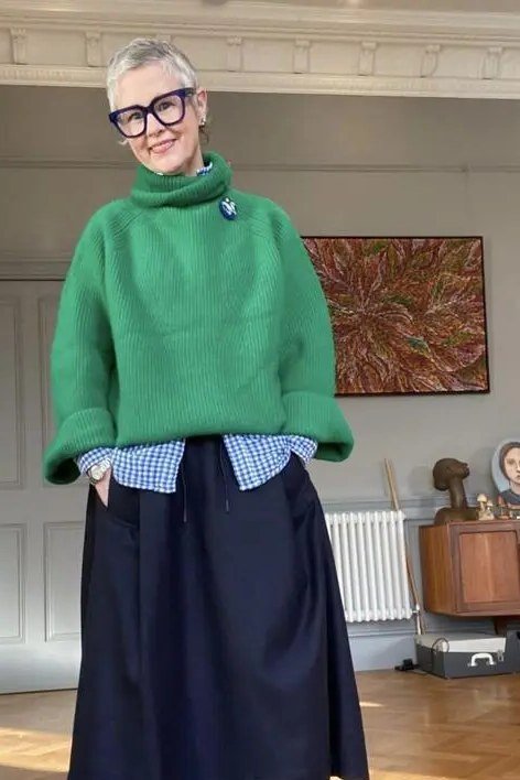 Fall turtleneck outfit for women over 50: green turtleneck with navy midi skirt, living room