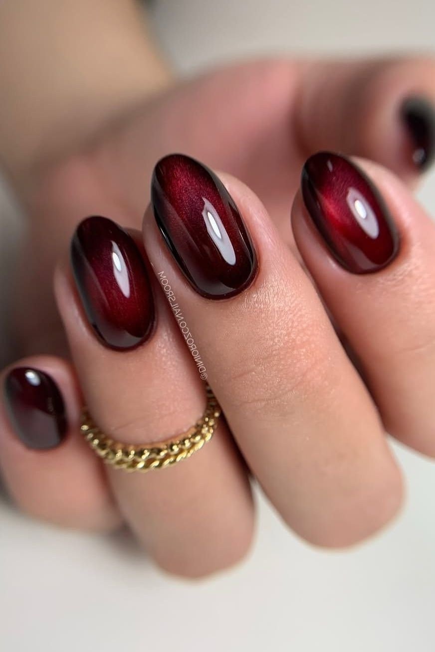 Deep burgundy cat eye, short oval, glossy - nail ideas for women over 40