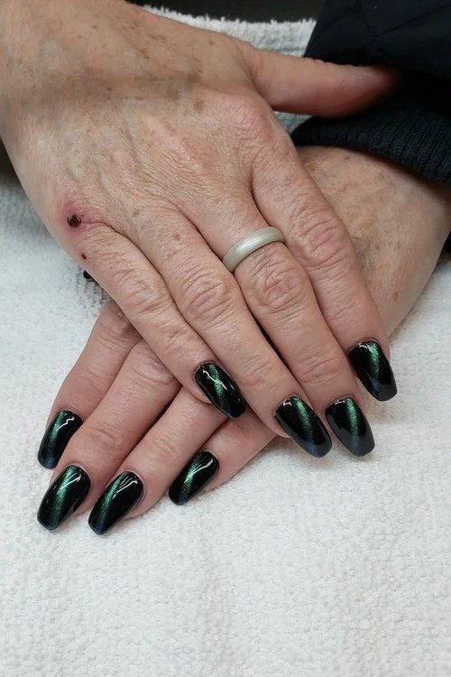 Emerald green cat eye on mature hands - nail ideas for women over 40