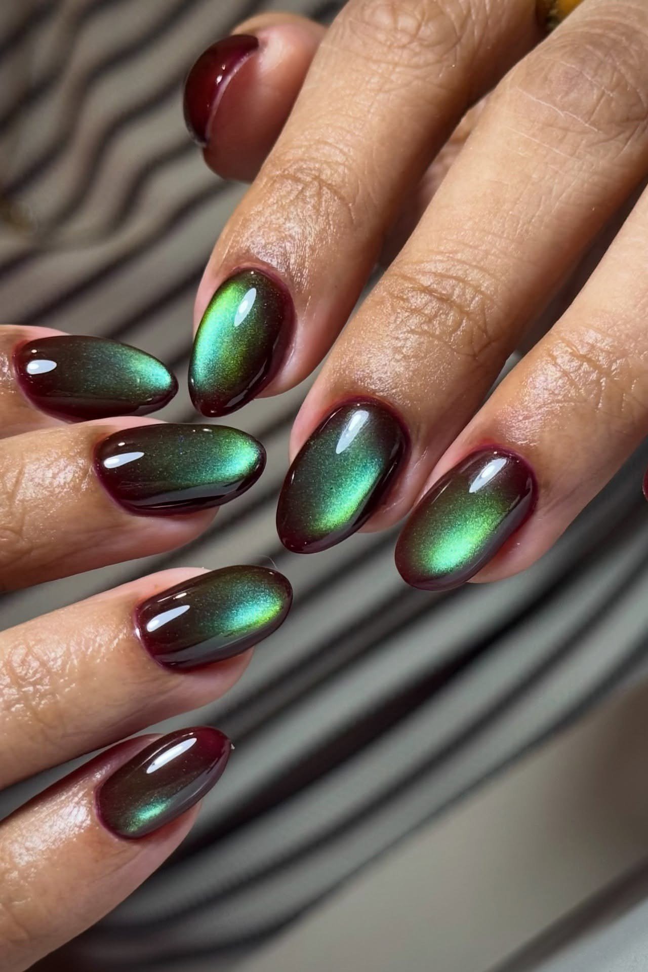 Black cherry velvet cat eye with emerald shimmer, almond - nail ideas for women over 40