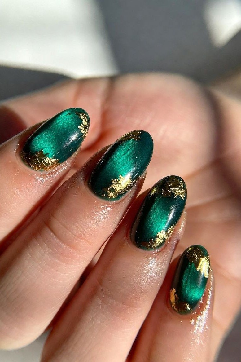 Emerald cat eye with gold foil accents, short oval - nail ideas for women over 40