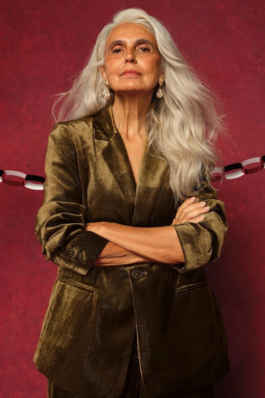 Gold Olive Velvet Blazer Against a Red Wall - velvet evening outfit for women over 60