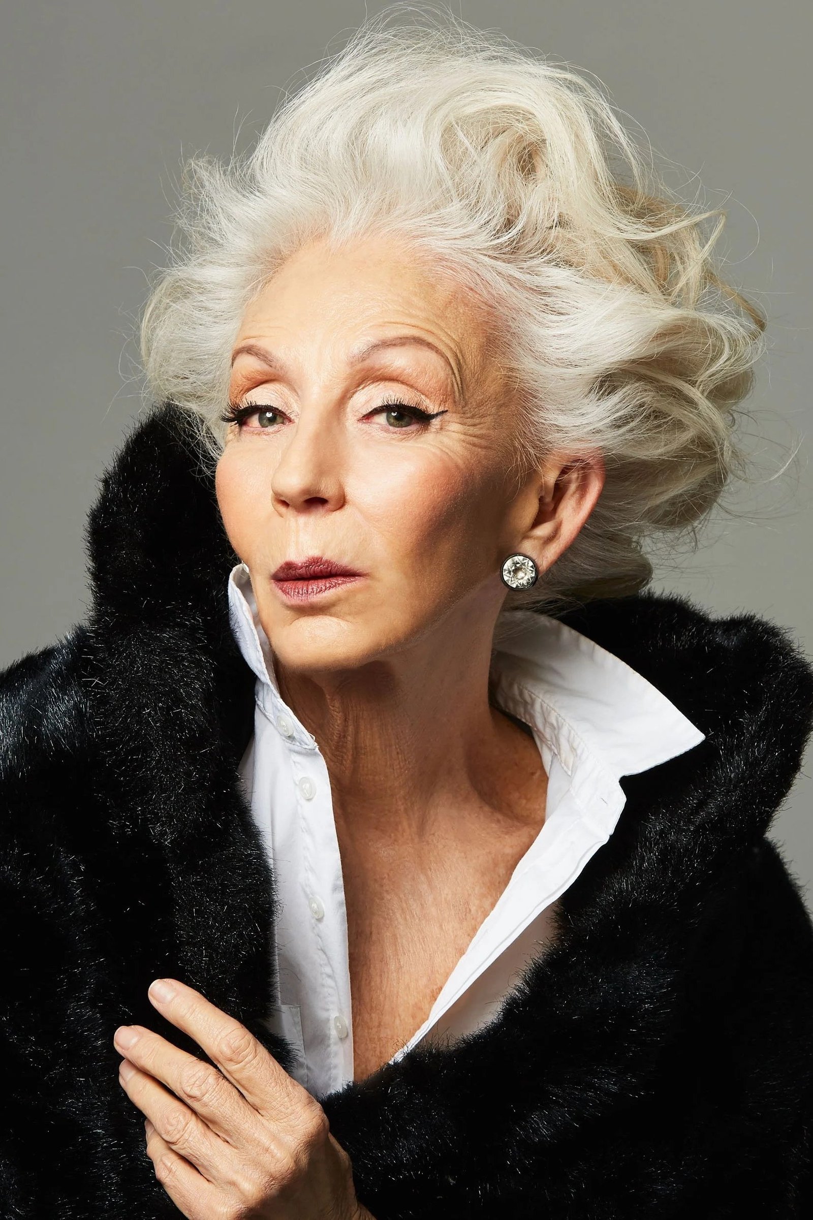 Winter outfit idea 1 for women over 60: black faux fur coat over white shirt, portrait glam