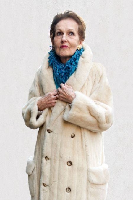 Winter outfit idea 3 for women over 60: cream shearling coat with blue knit scarf