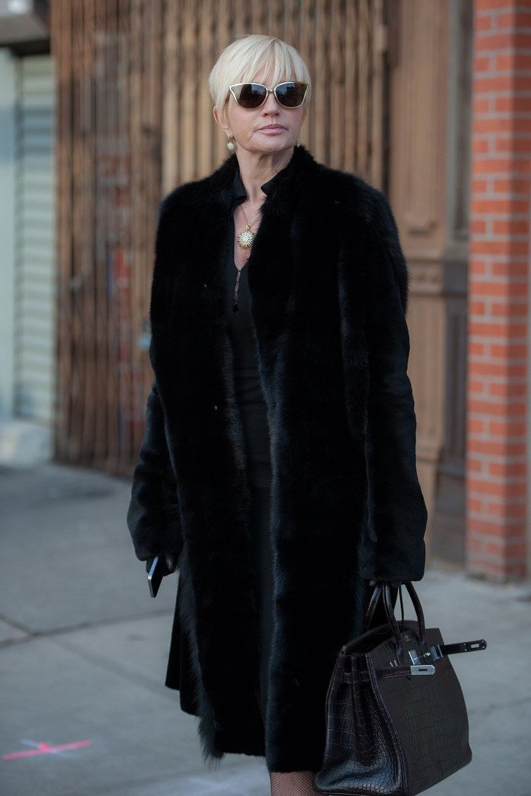 Winter outfit idea 14 for women over 60: black fur coat with sunglasses, street