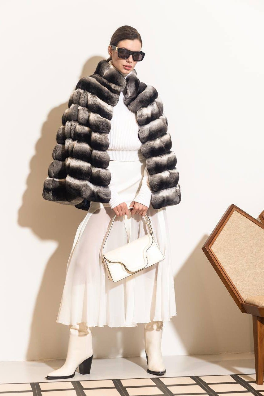 Winter outfit idea 20 for women over 60: striped fur coat with white pleated skirt and white boots