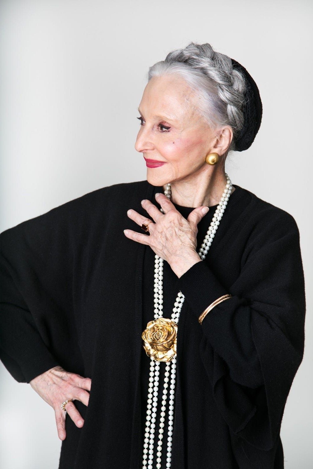 Winter outfit idea 25 for women over 60: black top with long layered pearl necklaces, updo