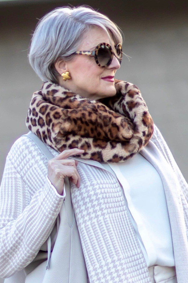 Winter outfit idea 46 for women over 60: white knit top with leopard scarf
