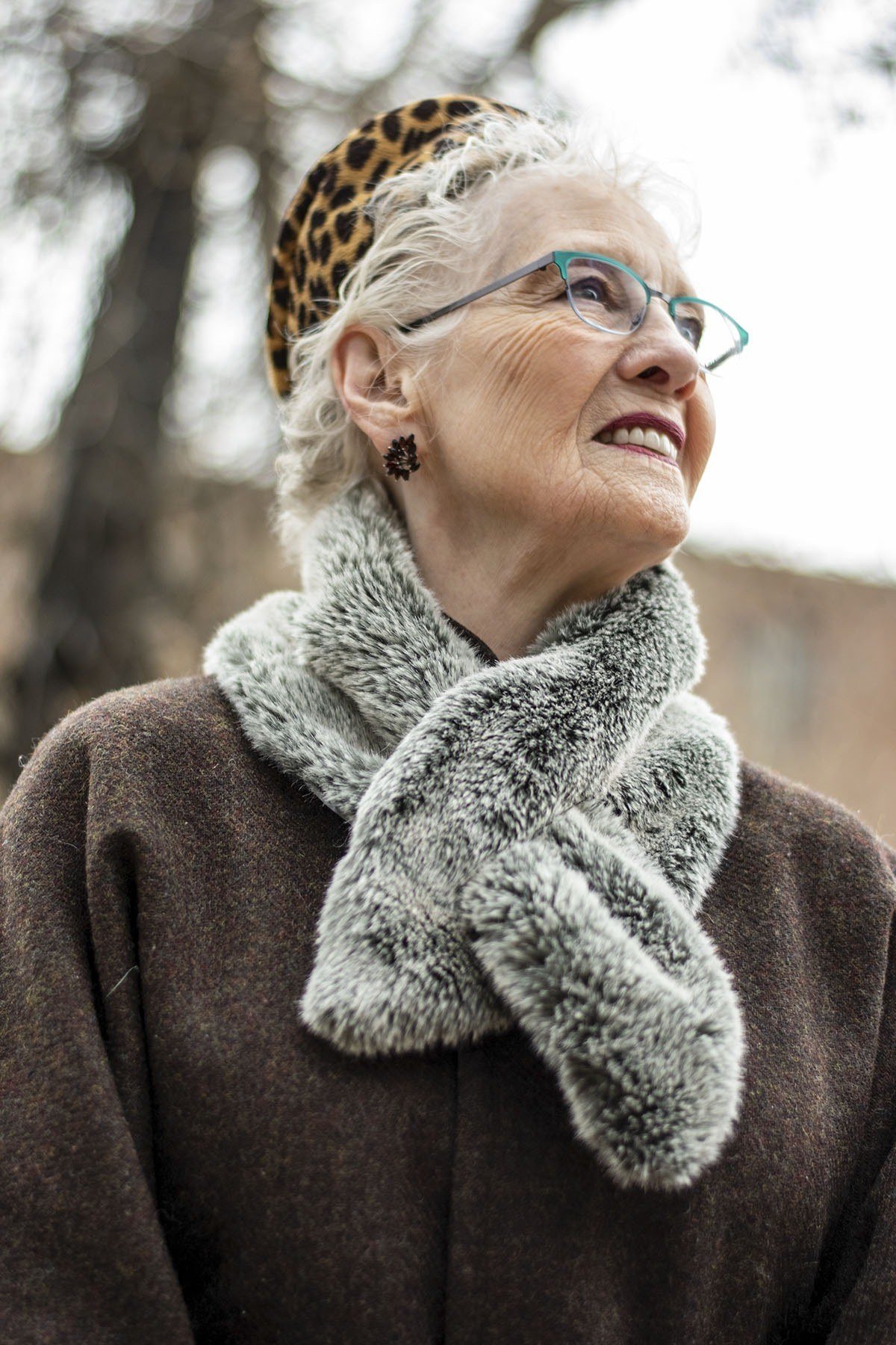 Winter outfit idea 50 for women over 60: leopard beret with grey fur scarf and brown coat