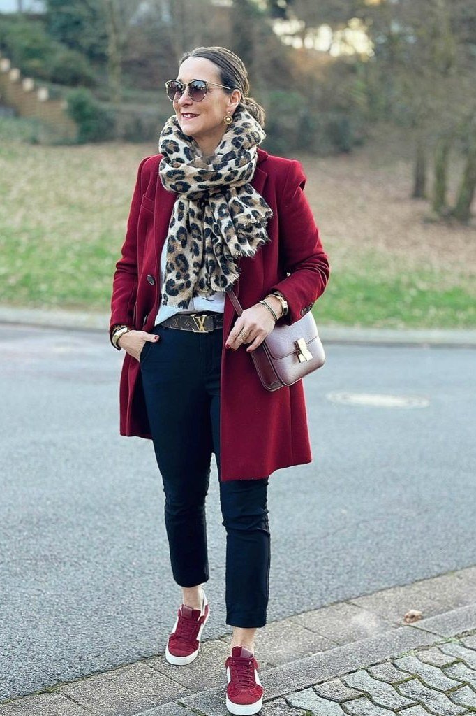 Winter outfit idea 52 for women over 60: burgundy coat with leopard scarf, city