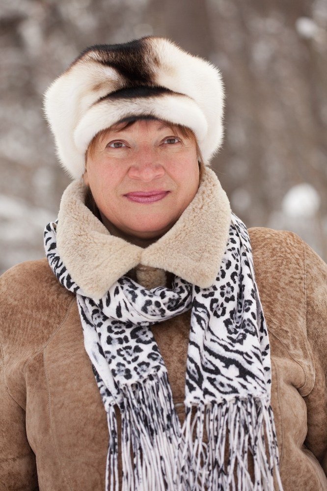 Winter outfit idea 57 for women over 60: fur hat with shearling coat and animal print scarf