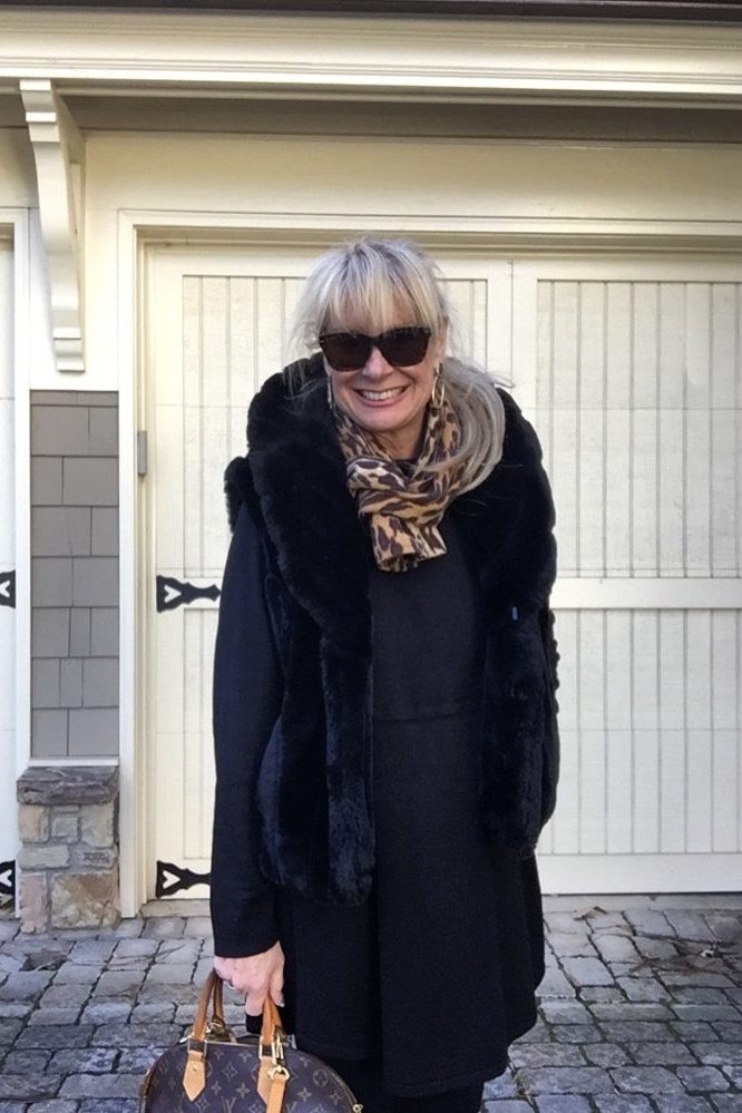 Winter outfit idea 58 for women over 60: navy fur-trim coat with leopard scarf, garage