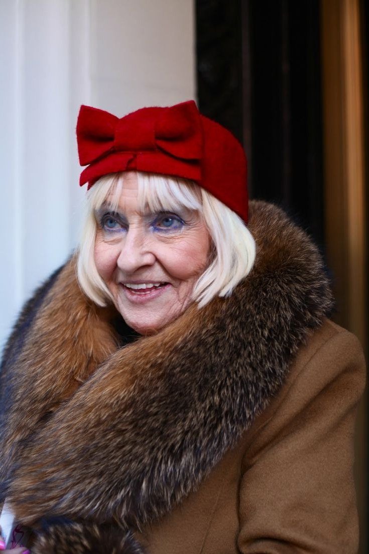 Winter outfit idea 68 for women over 60: camel fur-trim coat with red beret