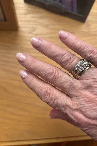 Pink nude almond nails with gold rings for women over 50