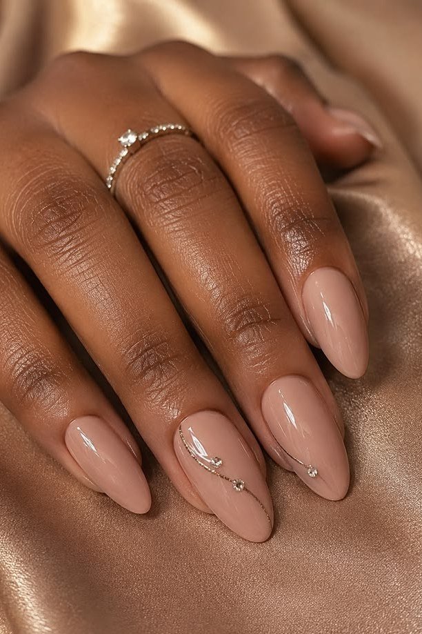 Warm beige nude almond nails with delicate accents for women over 50