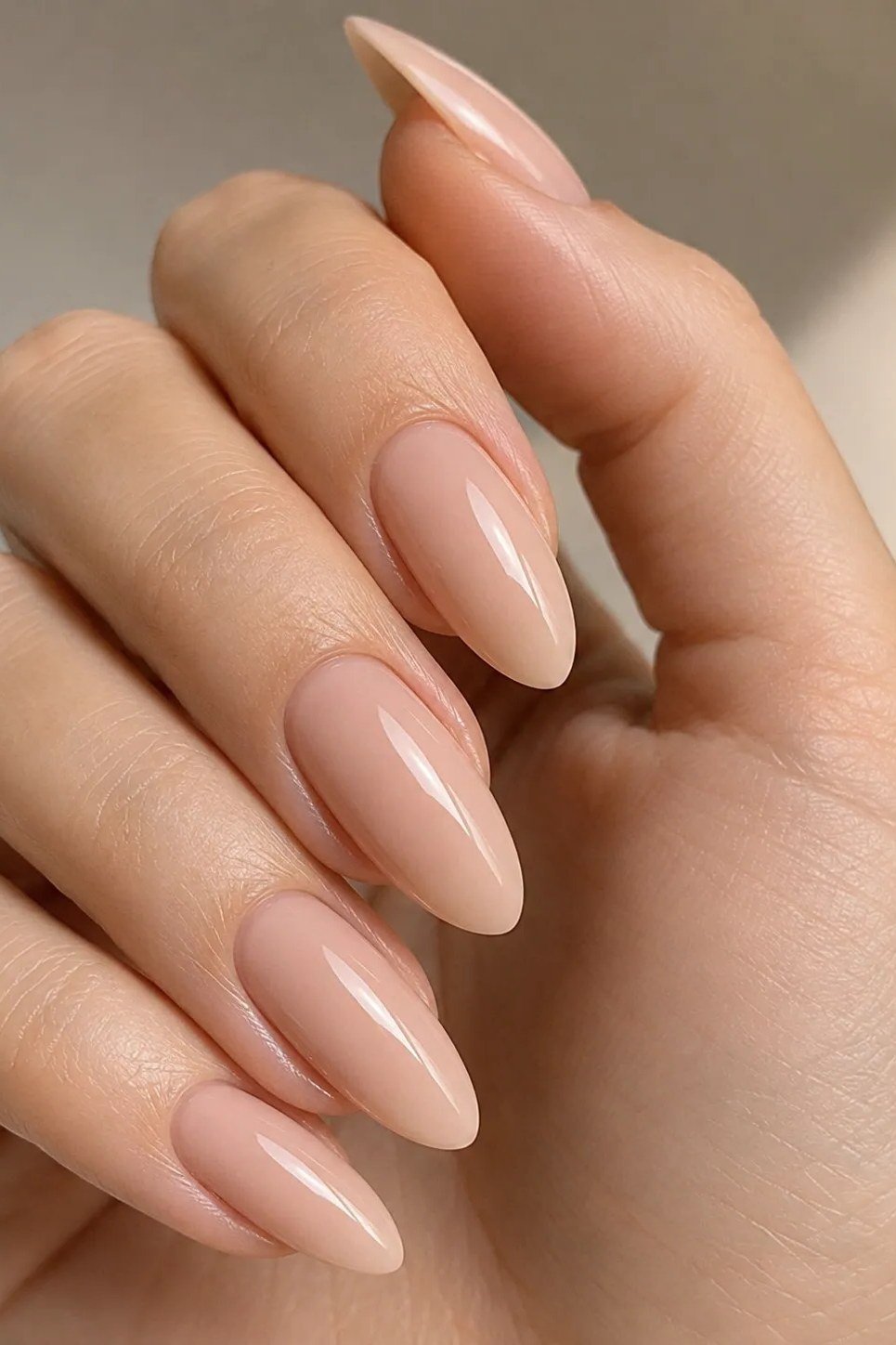 Glossy nude pink long almond nails for women over 50