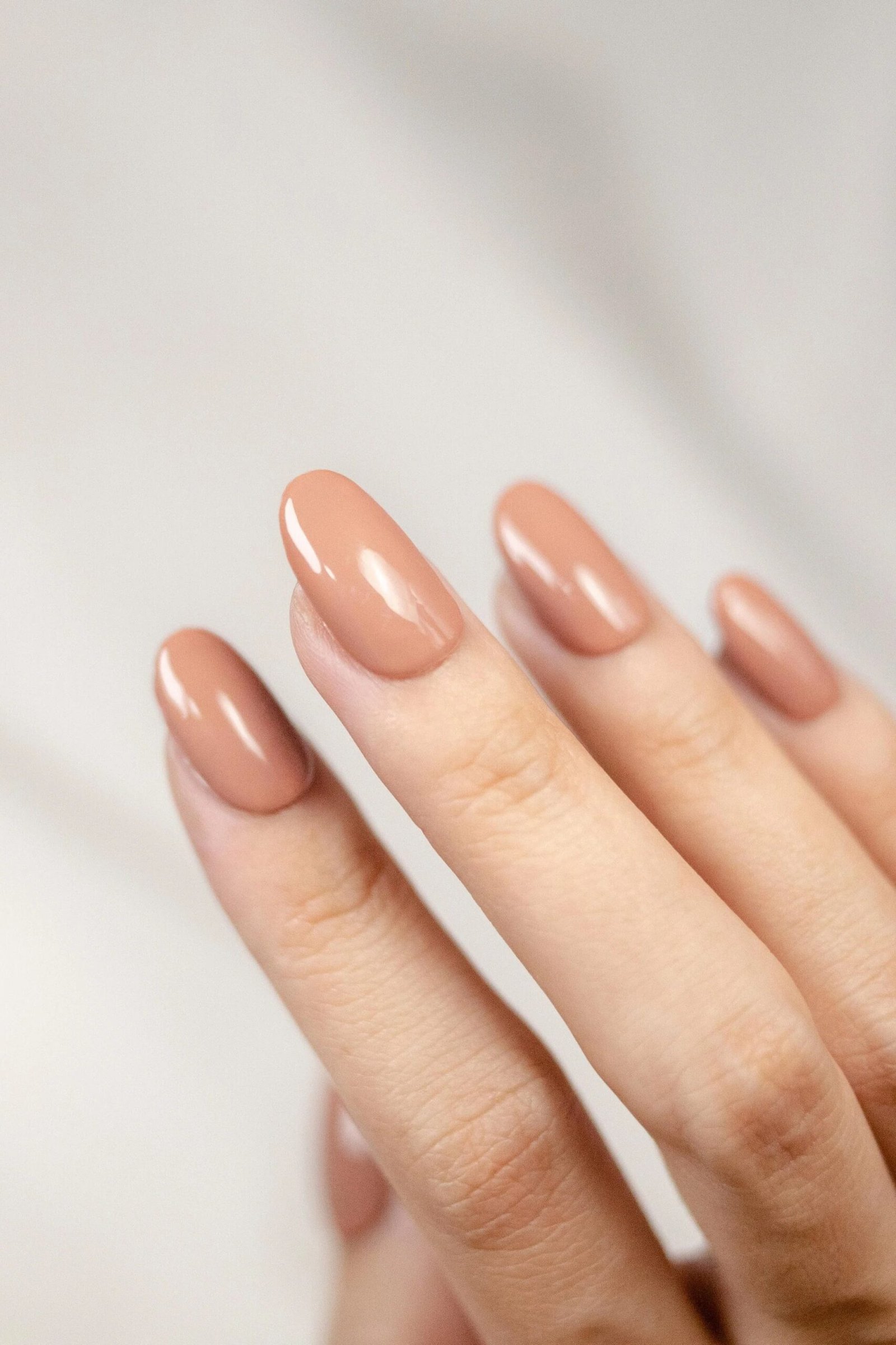 Warm peach nude short oval nails for women over 50