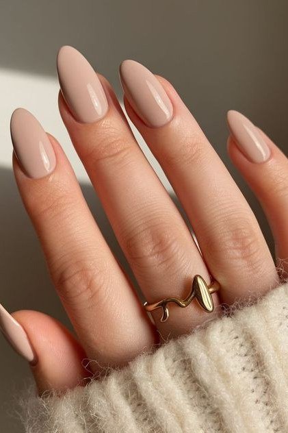 Warm beige nude long almond nails with rings for women over 50